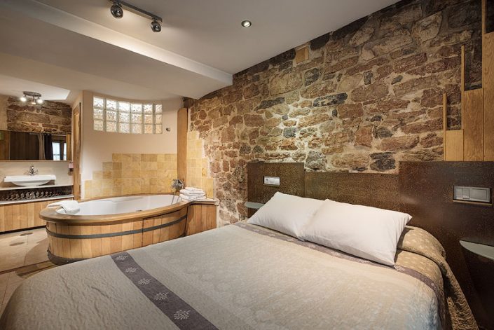 fotografía profesional de interiores de casa rural rústica de dormitorio con baño y jacuzzi en Asturias cerca de Cangas de Onís para airbnb y toprural